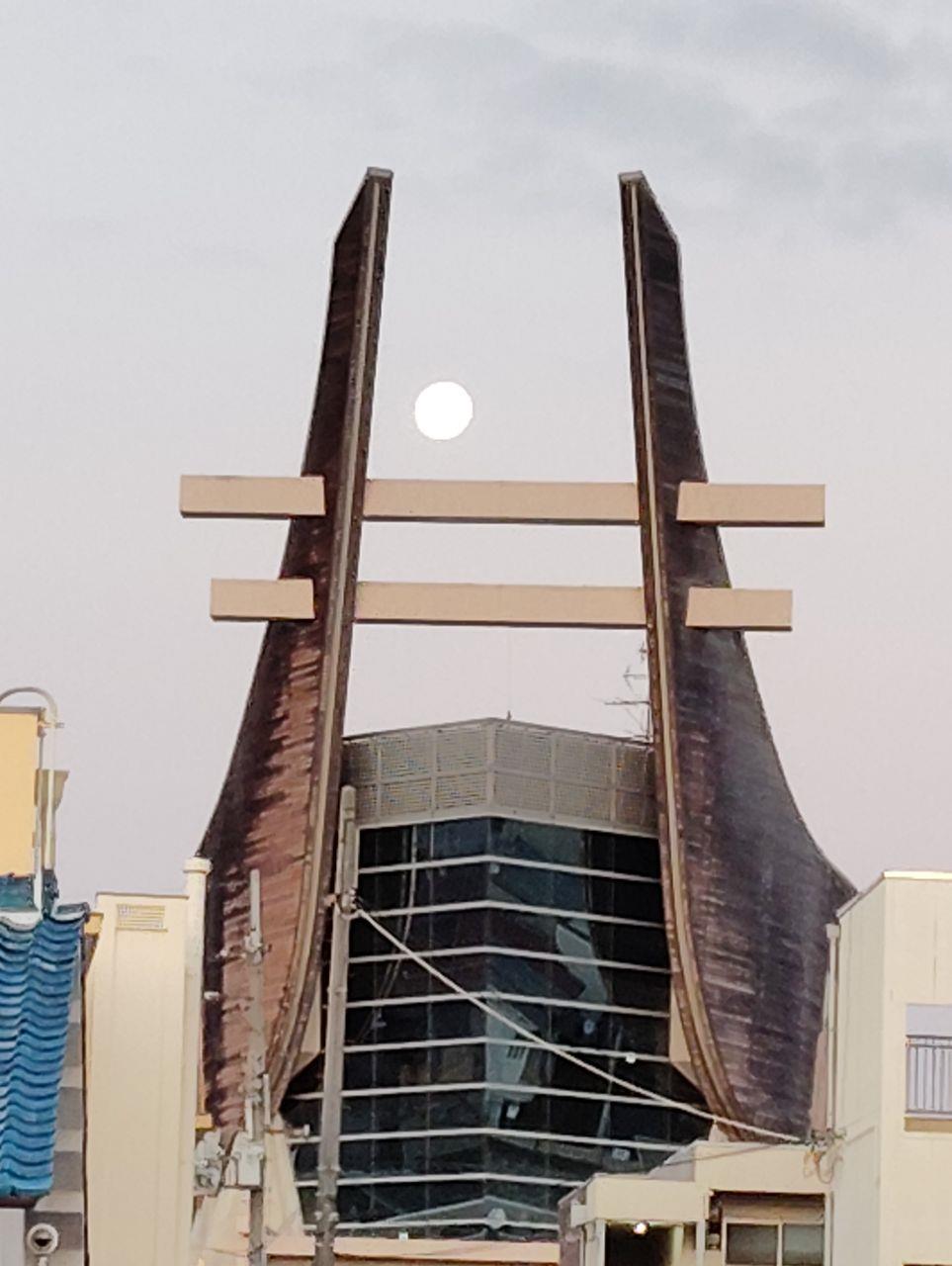 朝方のシュラホールに満月が浮かんでいる写真
