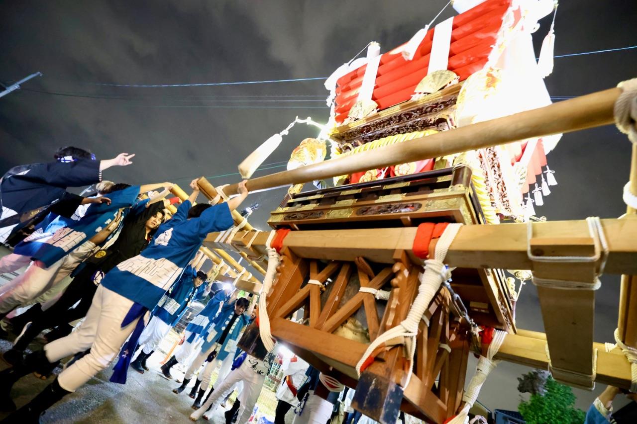 布団太鼓を担ぐ大勢の人の写真