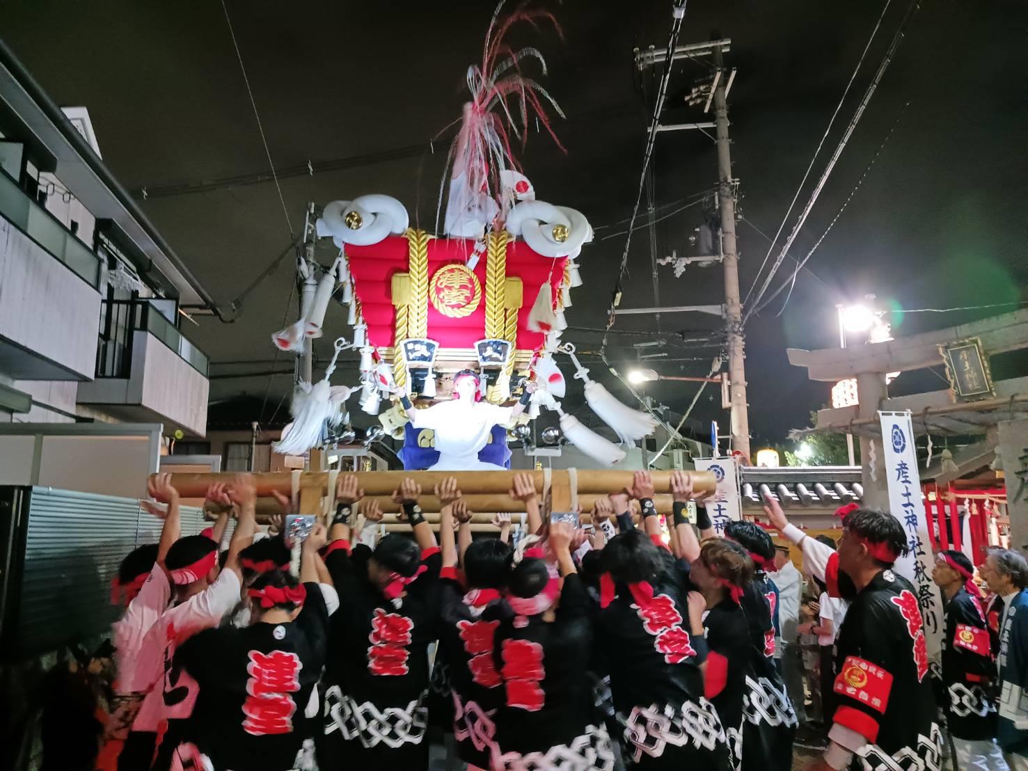 大勢が布団太鼓を持ち上げている写真