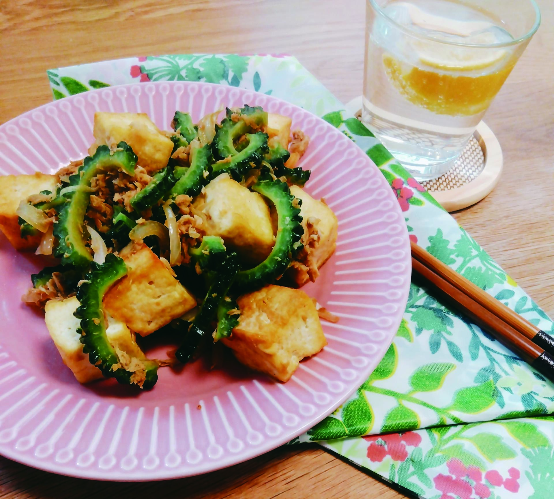 鮮やかな緑色のゴーヤとこんがりと焼かれた木綿豆腐が絡み合ったゴーヤチャンプルーの写真
