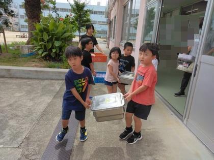 小学校の給食室から食器や食缶を運んでいます。