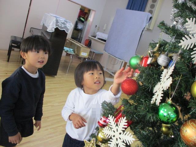 友達と一緒に飾ったクリスマスツリーをみて、楽しい雰囲気を感じている子ども達です。