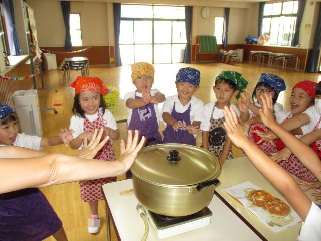 カレーライスの仕上げに、お鍋の周りに子供たちが集まって「おいしくなぁれ！」と魔法をかけています。