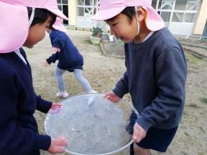 氷をもって見つめる子どもたち