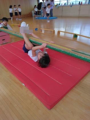 腕と足の力を使って巧技台を渡っている