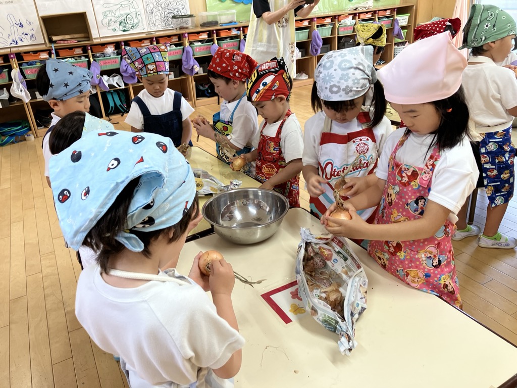 玉ねぎの皮をむく4歳児