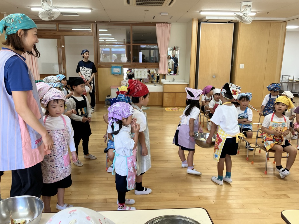 5歳児に玉ねぎを渡す4歳児
