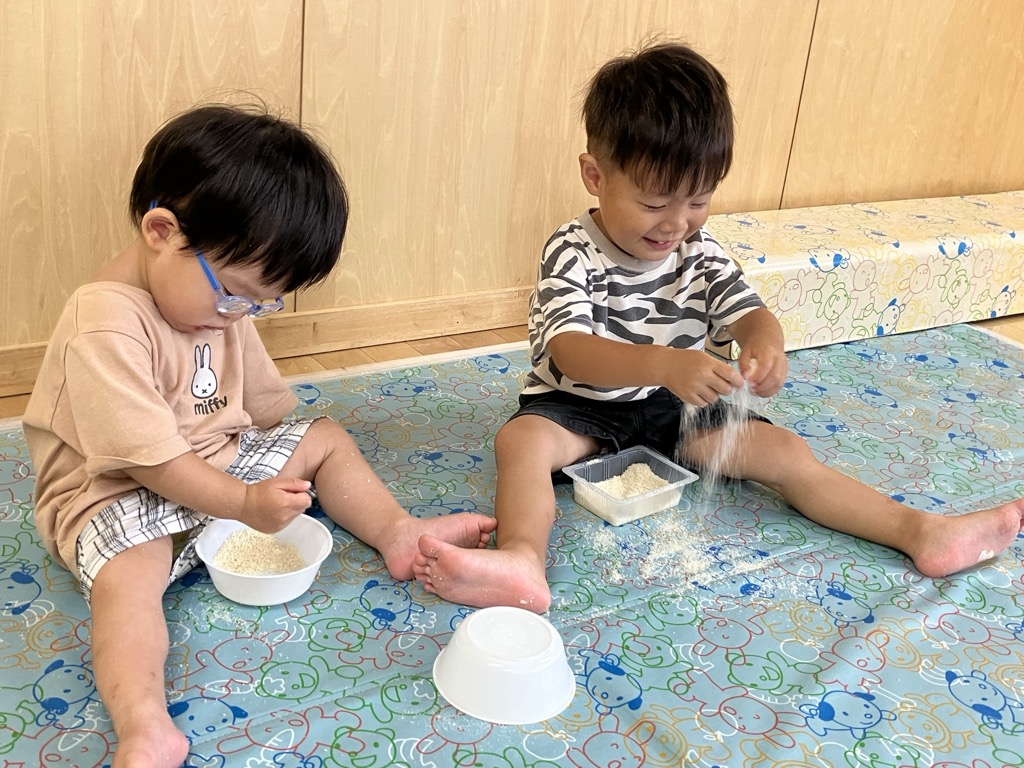 パン粉で遊ぶ子ども達