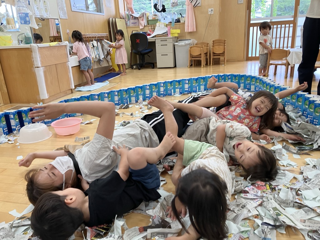 新聞紙のプールで遊ぶ子ども達
