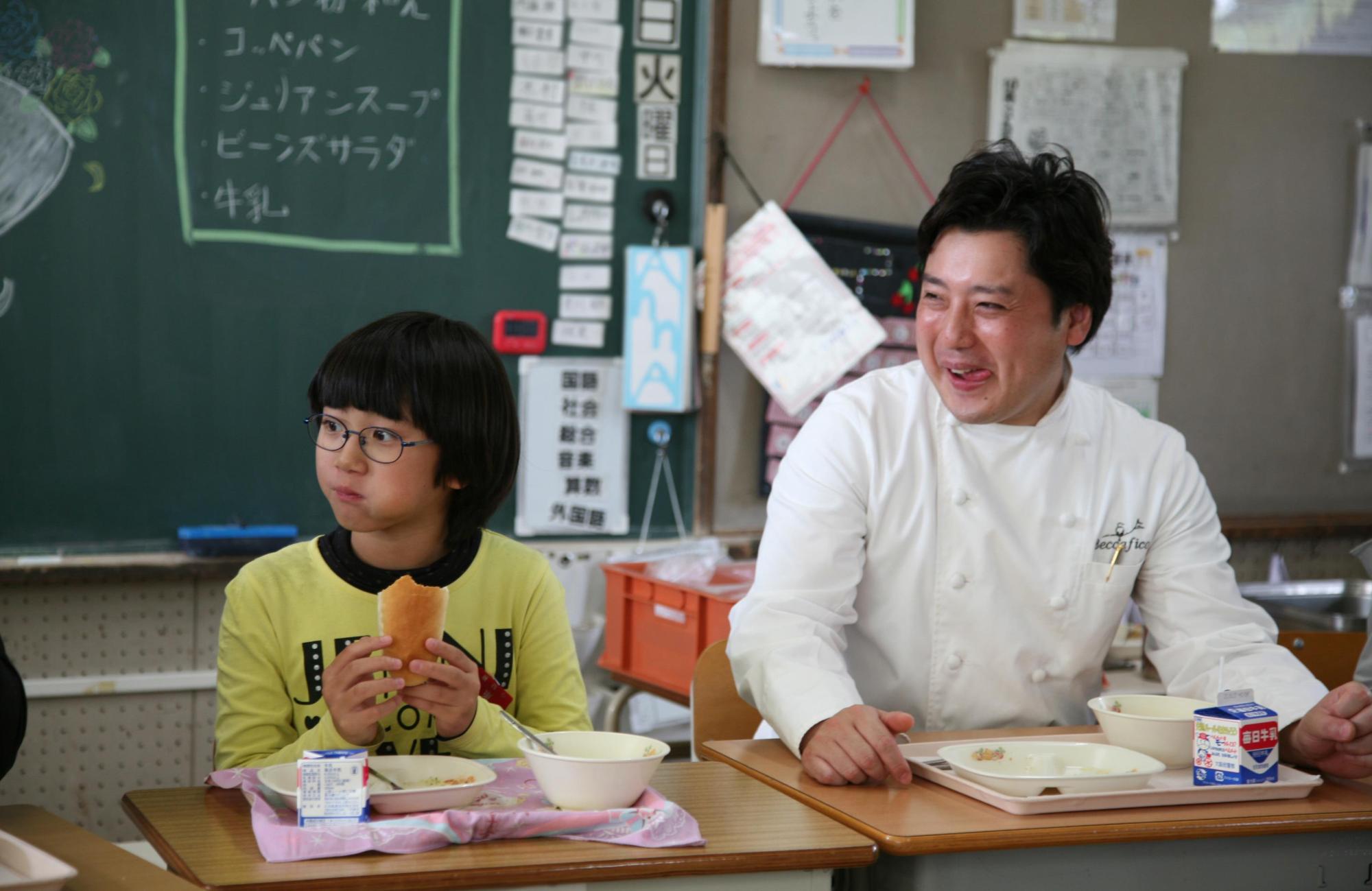 藤井シェフと子どもが楽しく給食を食べる様子の写真