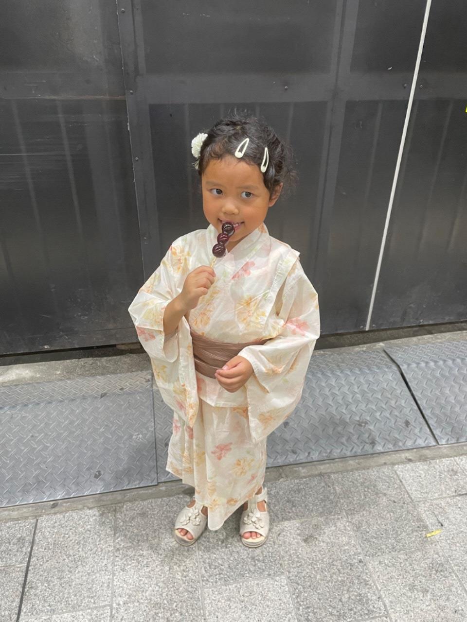 浴衣をきて飴を舐めるこどもの写真