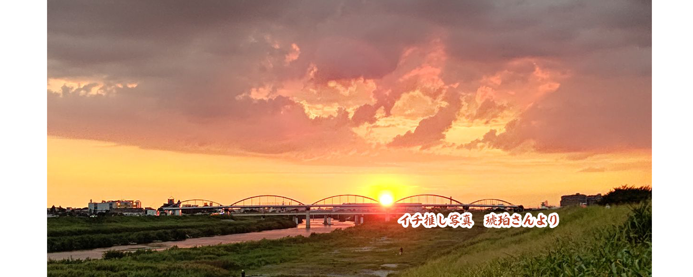 河川敷に夕陽が差し込んで空がオレンジ色になっている写真