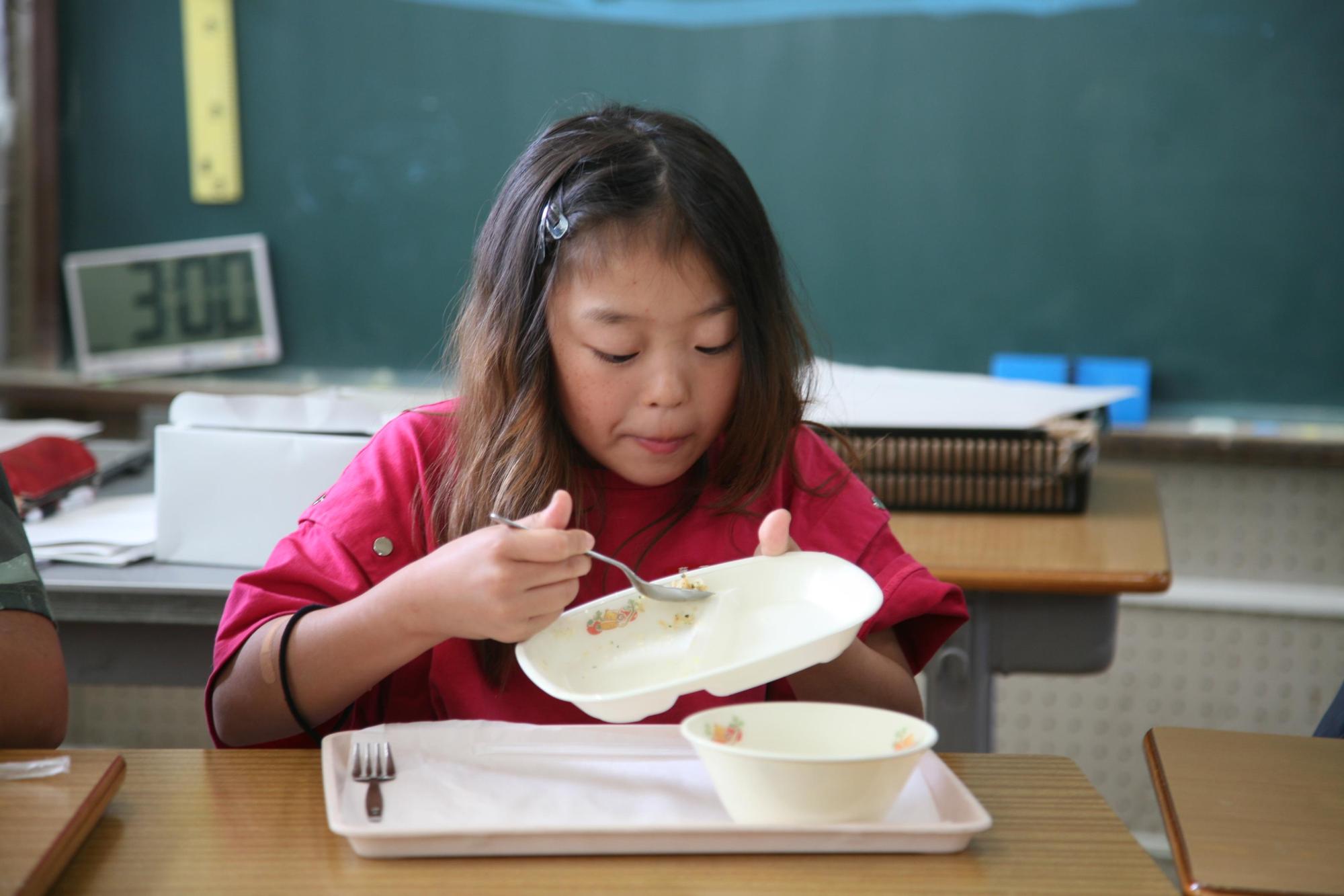 女の子が給食を食べている様子の写真