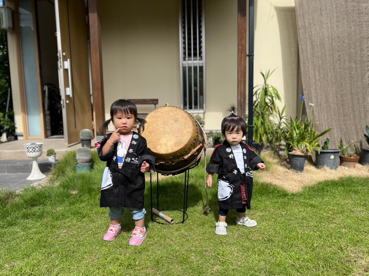 太鼓の前で立つ法被を着たお子さん二人の写真