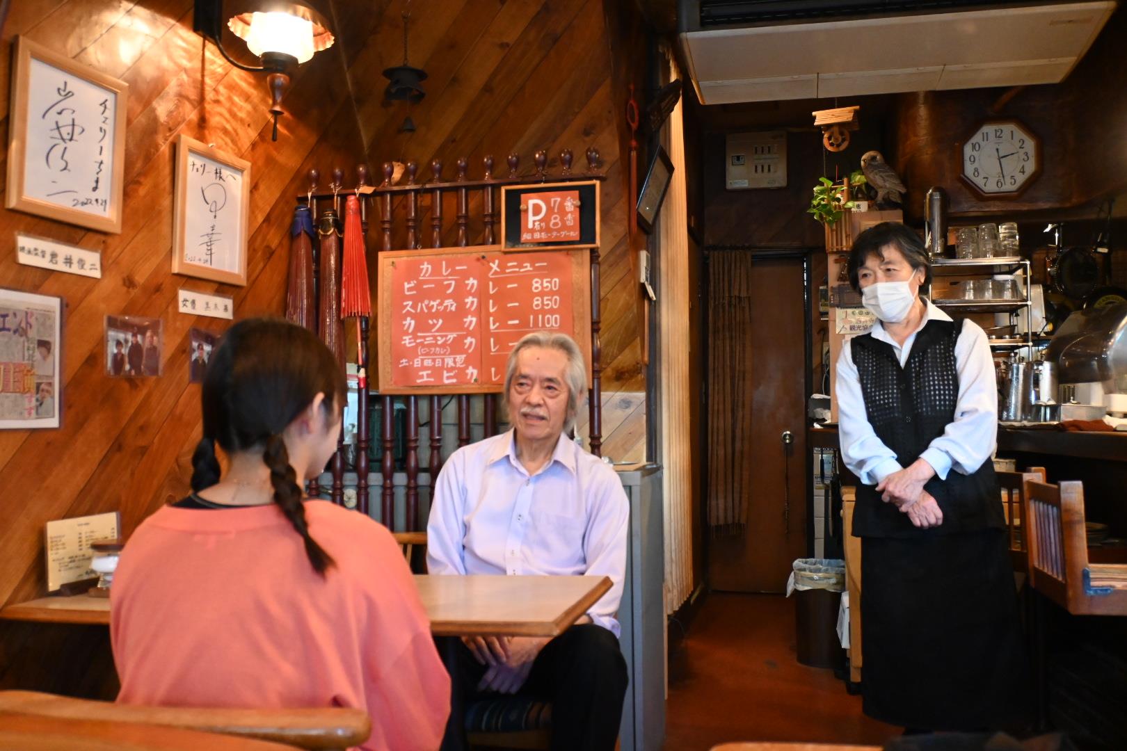 四天王寺大学学生広報スタッフが珈琲館チェリー店主上田さんへインタビューをする様子