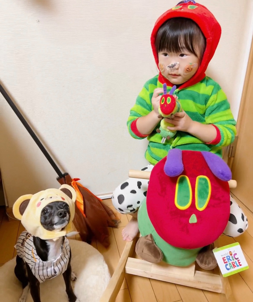 被り物を被っている犬とキャラクターの格好をして木馬に乗っているお子さんの写真