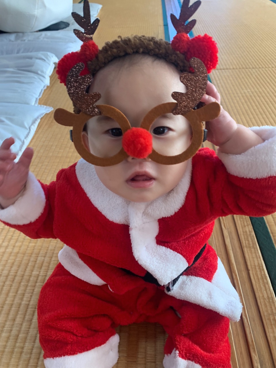 サンタ服を着てトナカイの眼鏡をかけているお子さんの写真