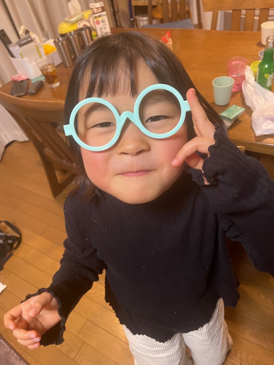 おもちゃの眼鏡をかけて微笑んでいるお子さんの写真