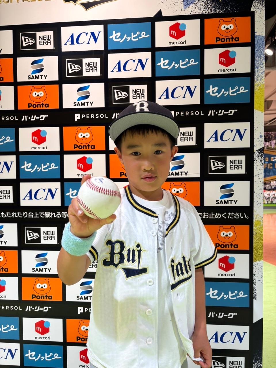 プロ野球観戦で取ったファウルボールを手に喜ぶ子供の写真