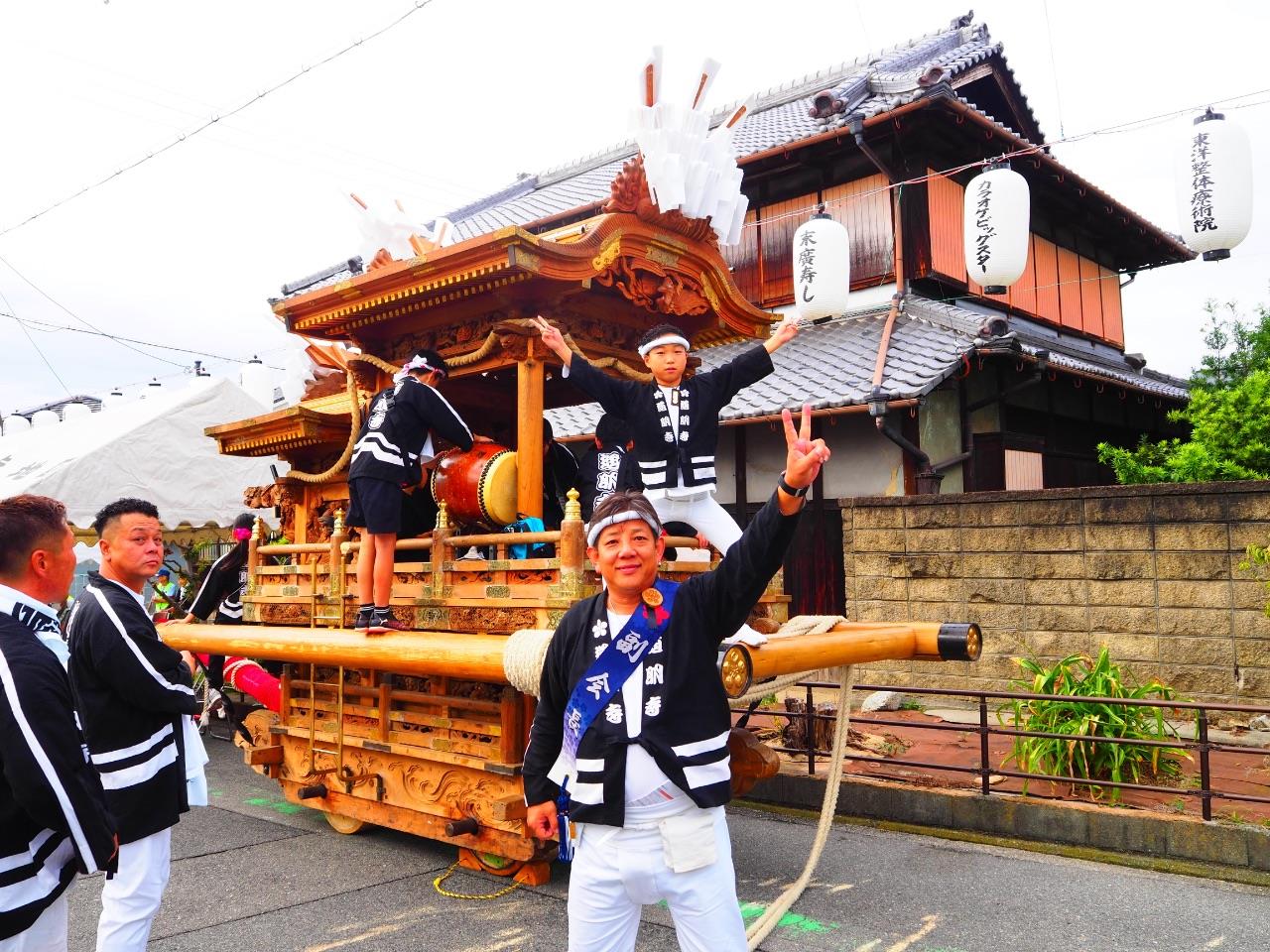 だんじりの前でピースしている写真