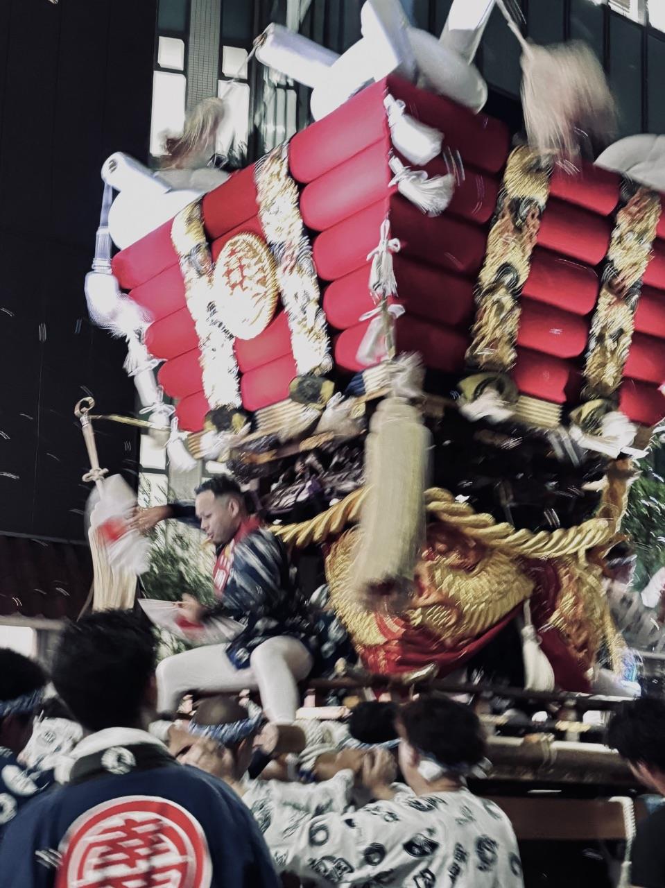 布団太鼓が勢いよく担がれている写真