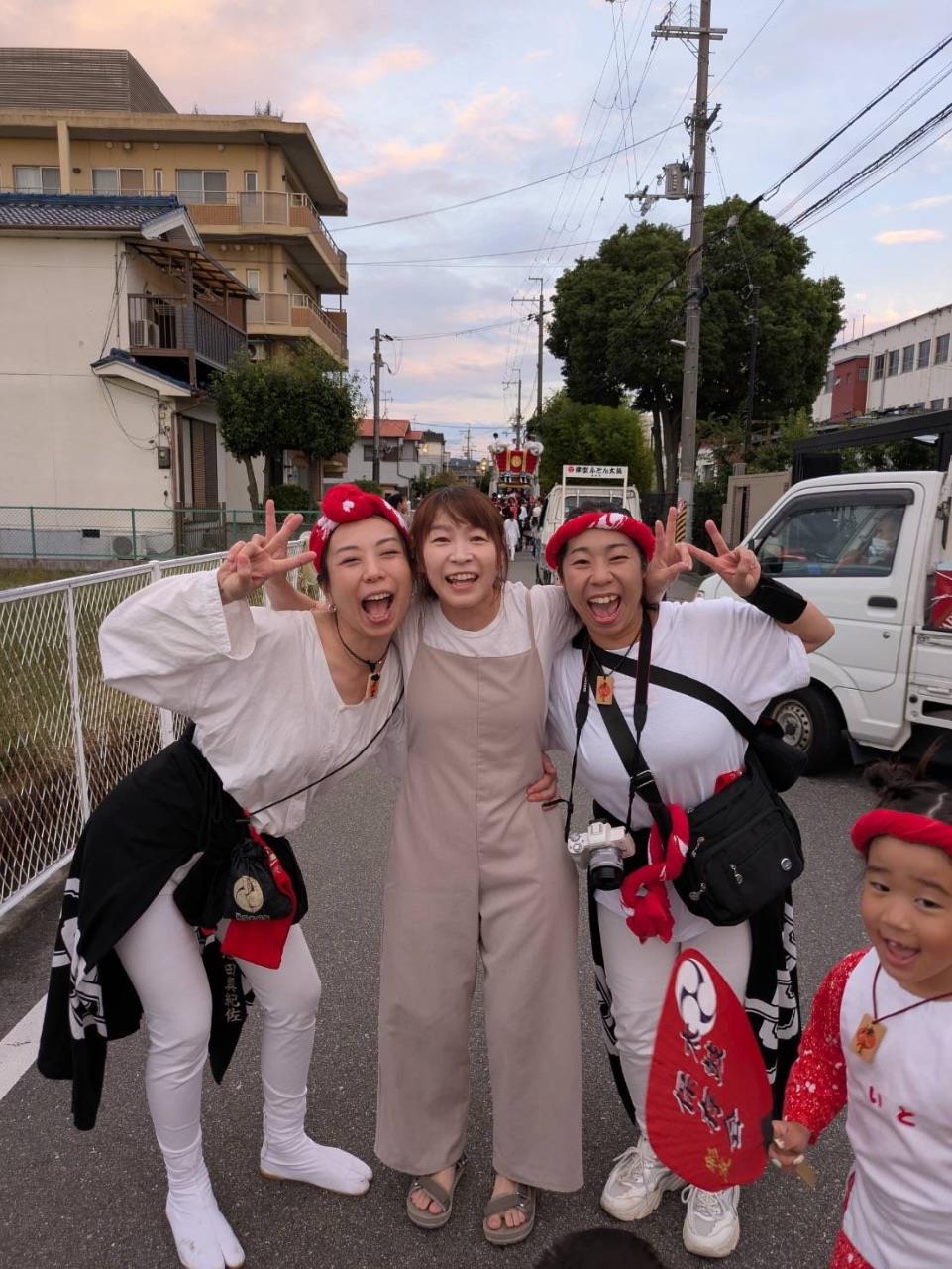 お友達同士で肩を組んでピースをする人の写真