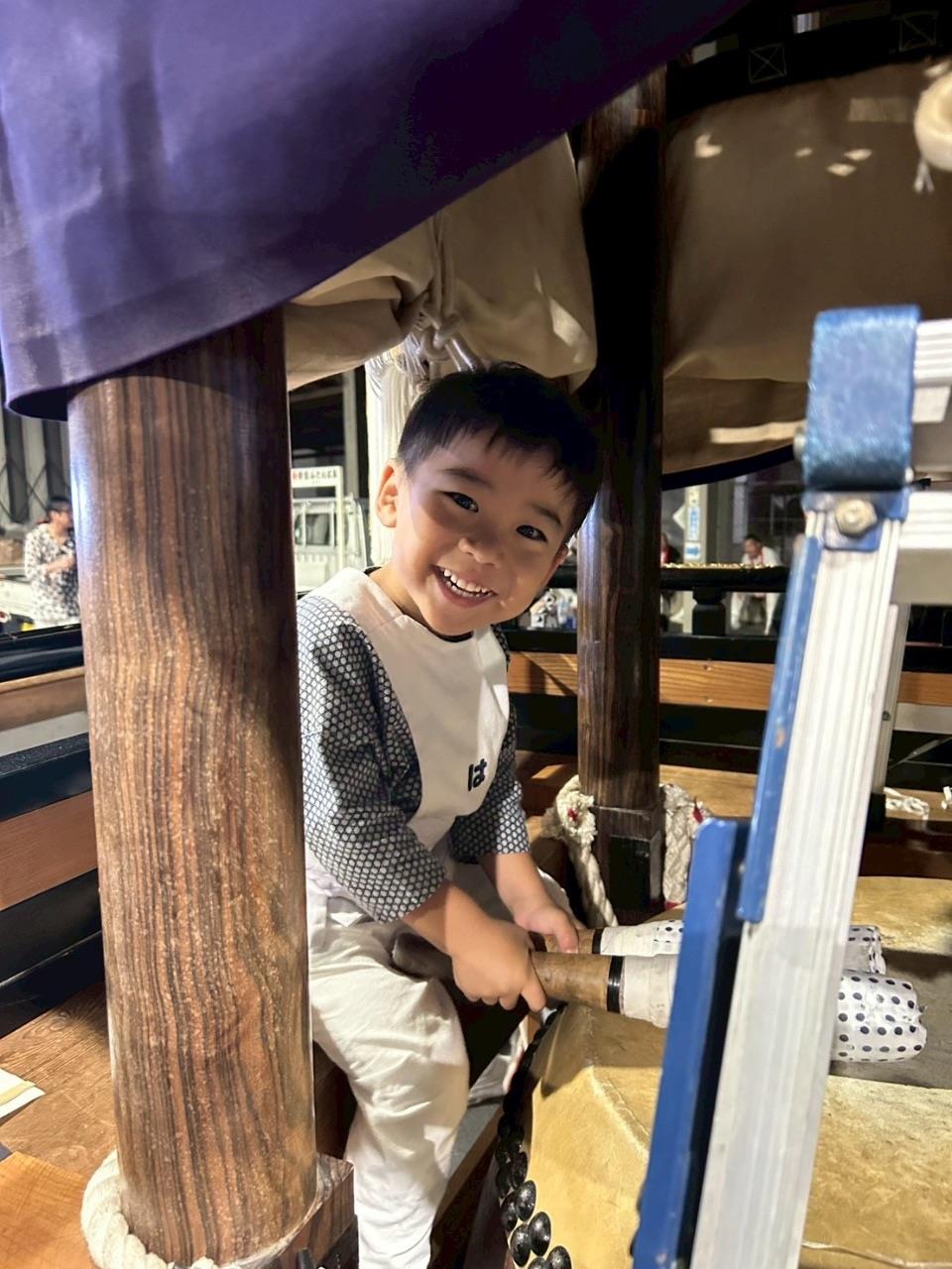 布団太鼓の中で太鼓をたたくお子さんの写真