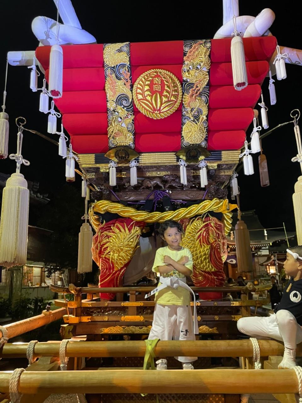 布団太鼓に乗ってポーズをするお子さんの写真