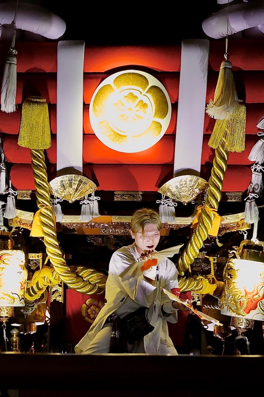 布団太鼓の真ん中で舞う人の写真