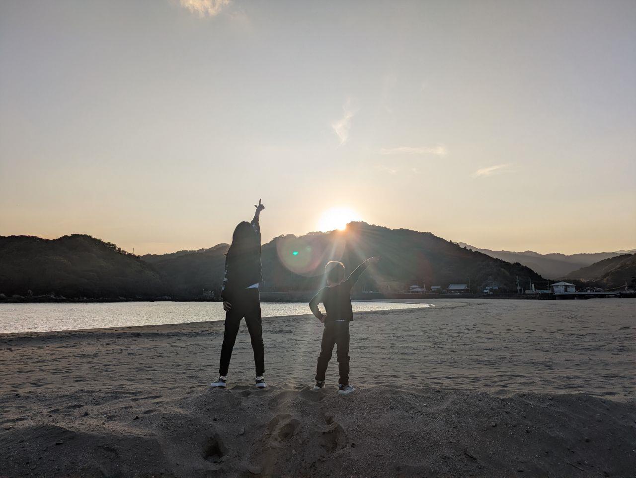 夕日を指さす姉弟