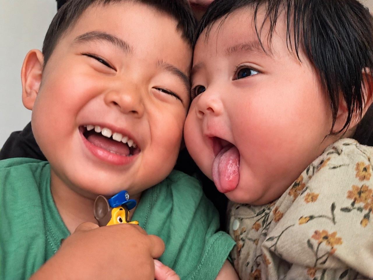 お子さん二人が頬を寄せて笑っている写真