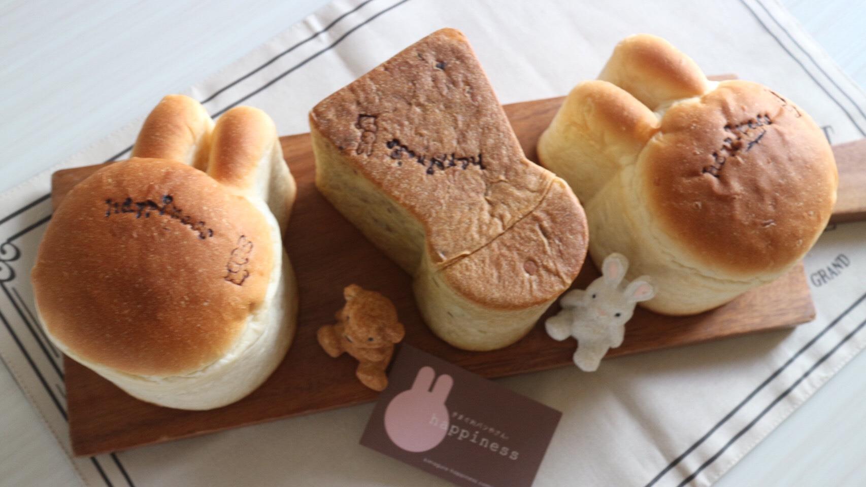 左からうさぎ型のパン、前方後円墳型のパン、うさぎ型のパンと3つのパンがかわいく並んでいる。うさぎとクマのぬいぐるみとショップカードが添えられている。