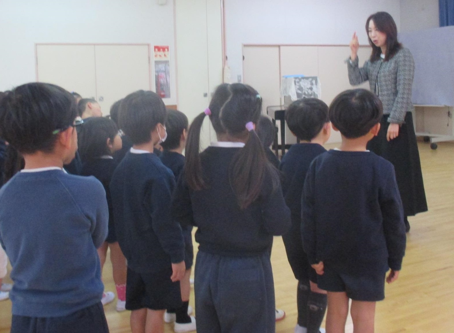 終業式で園長先生からお話を聞いている