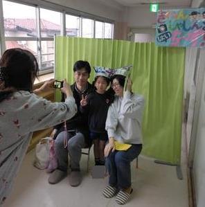 作った新聞帽子をかぶって、家族で記念撮影をしています。