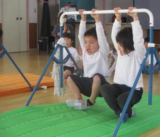 鉄棒の握り方を教えてもらい、20秒鉄棒にぶら下がっています。