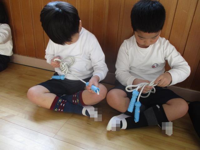 縄跳びの縄を半分にたたんで、輪っかを作りくぐらせ結びます。