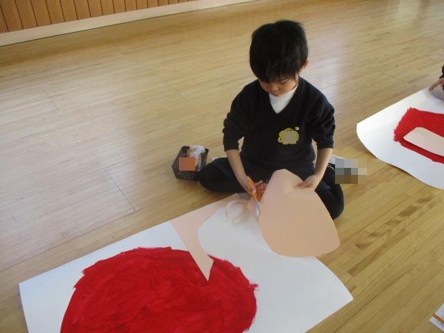 1月の壁面装飾は、だるま。絵の具で描いた体の大きさに合う顔の形を画用紙で作っています。
