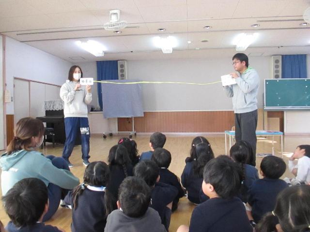 子ども達の前で、紐の先につけたカードを使って、飛沫距離の長さを示し、一緒に体感しました。