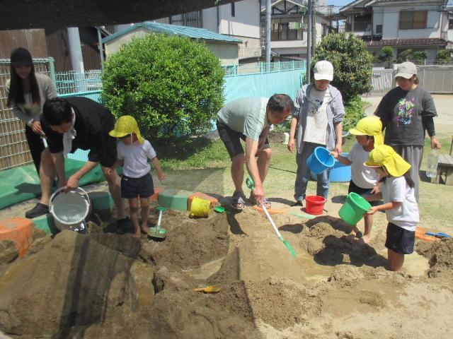 道を掘っていたら、友達が作った山と山がくっついて喜んでいます。