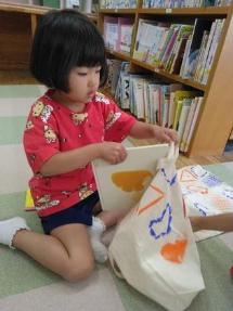 借りた本をかばんに入れています。