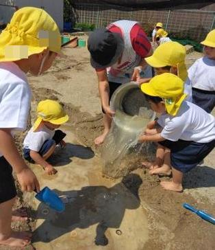 ペットボトルだけでは物足りずたらいに水を汲んでみんなで運んで流しています。