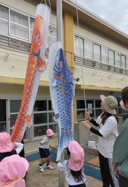 空へ掲げる様子を子ども達が見守っています。