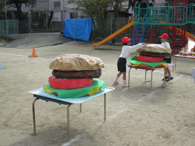 ハンバーガーの具材を運んでビッグバーガーをつくる競技をしています。