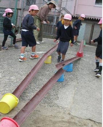 自分たちで作った坂道スロープのオリジナルコースで、まつぼっくりやどんぐり、くりを転がして遊んでいます。