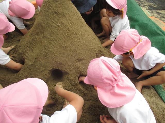 作った山にトンネルを掘って、友達とつなげようとしています。
