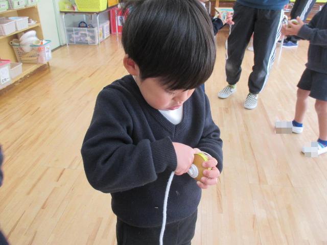 コマの芯に上手に紐を巻き付けています。