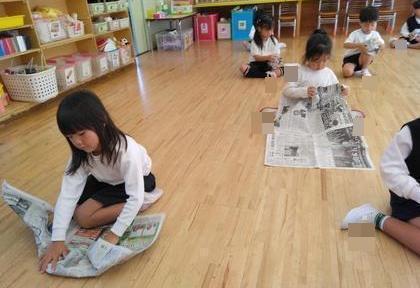 新聞紙を丸めて何かの形を作っています。