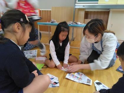 紙鉄砲の折り方を教えてもらっています。