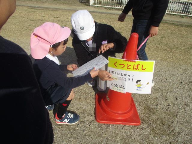 くつとばしのコーナーで遊んだ後、カードにシールを貼っています。