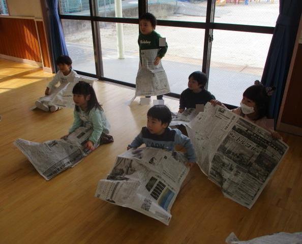 新聞紙を大きく広げて、洋服みたいに当てて変身ごっこをしたり、お腹にくっつけたまま落とさないように歩いたりして遊びます。